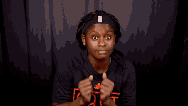 a woman wearing a headband and a black shirt that says as