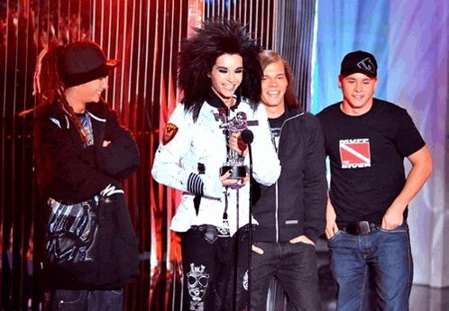 a man wearing a shirt that says dance storm stands next to two other men