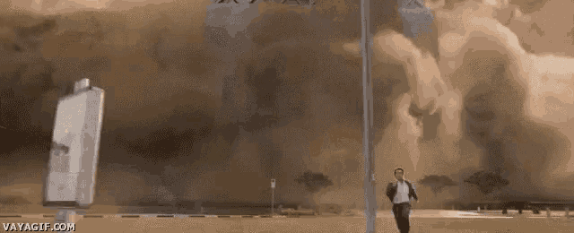 a man is running from a tornado in a field