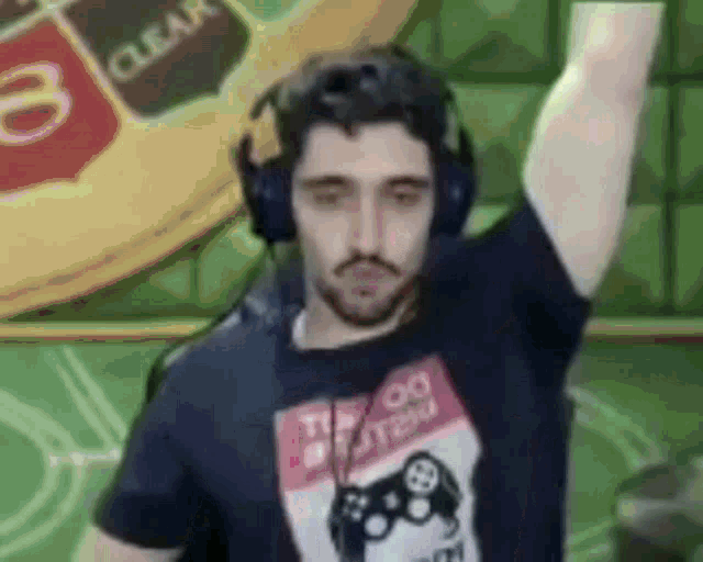 a man wearing headphones and a t-shirt with a game controller on it is dancing .