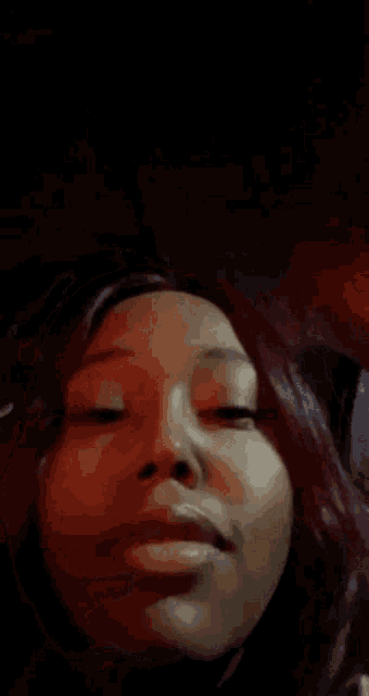 a close up of a woman 's face with red hair making a funny face .