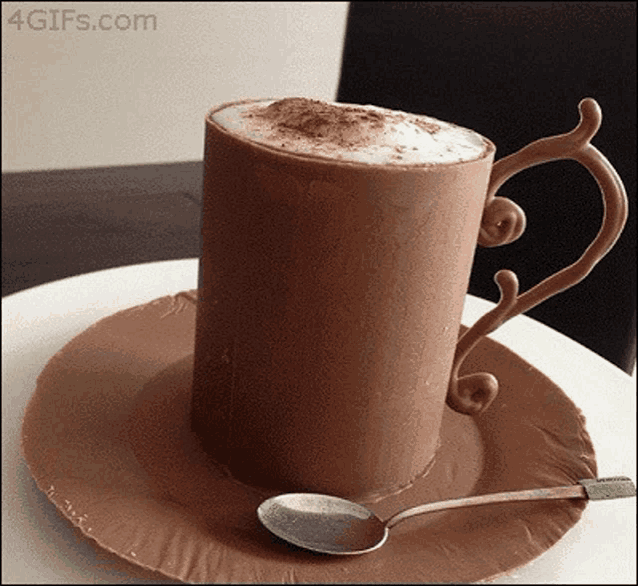 a cup of coffee made out of chocolate with a spoon on a saucer