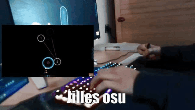 a person is playing a video game on a keyboard and a screen behind them says jilles osu