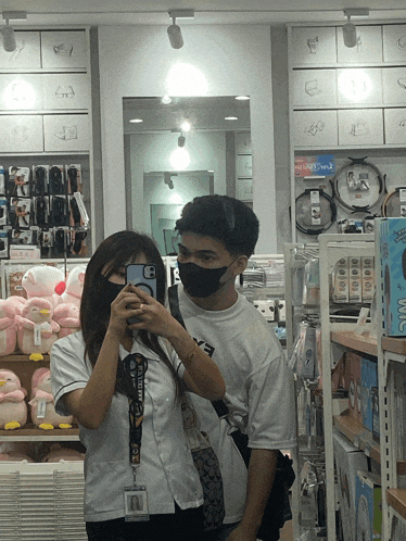 a man and a woman are taking a picture of themselves in a store with a lanyard that says abercrombie