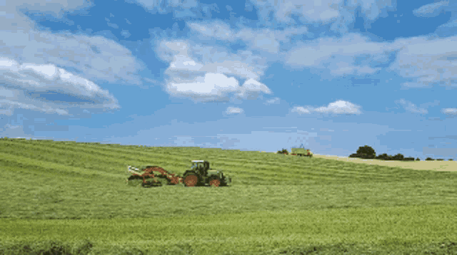 a tractor is cutting grass in a field