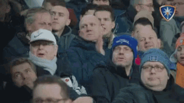 a crowd of people sitting in a stadium with one wearing a hat that says ' united ' on it