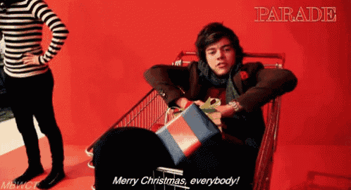 a man in a shopping cart says merry christmas