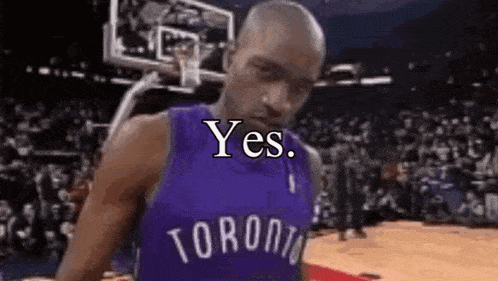 a man in a toronto raptors jersey is standing on a basketball court with a basketball hoop in the background .