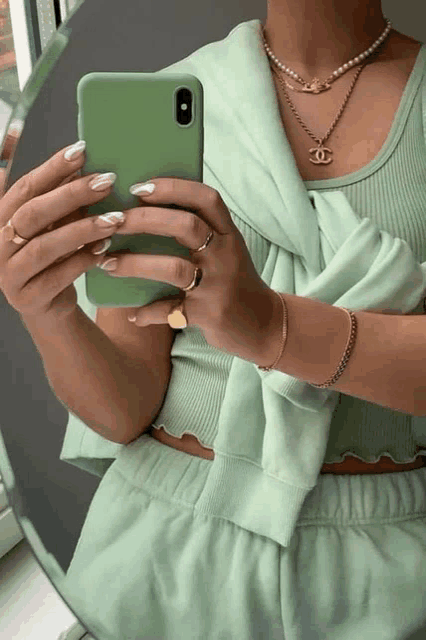 a woman is taking a picture of herself in a mirror with her phone