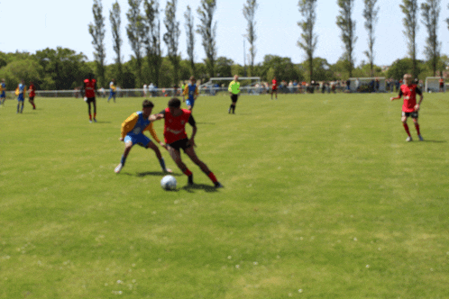 a blurry picture of a soccer game with players wearing red and yellow