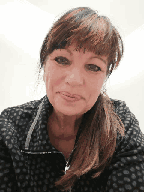 a woman wearing a black jacket with polka dots on it