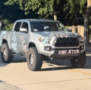 a toyota tacoma truck with the word cheater painted on the bumper