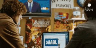 two people sitting in front of a laptop that says $ aabl