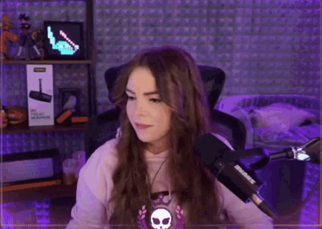 a woman is sitting in front of a microphone .