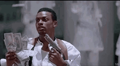 a man is holding a gun and holding a bunch of money .