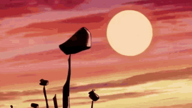 a sunset with a bucket in the foreground and a large sun in the background