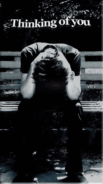 a black and white photo of a man sitting on a bench with the words thinking of you above him