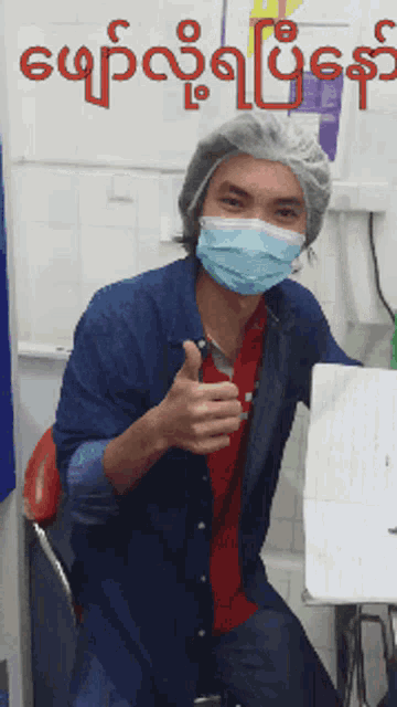 a man wearing a mask is giving a thumbs up sign