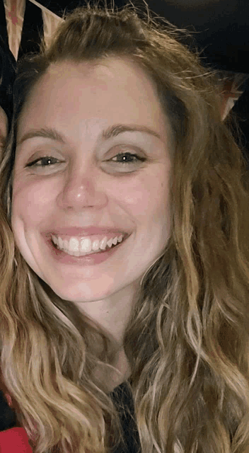 a close up of a woman 's face smiling with her eyes closed