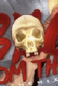 a close up of a skull on a wall with red letters on it .