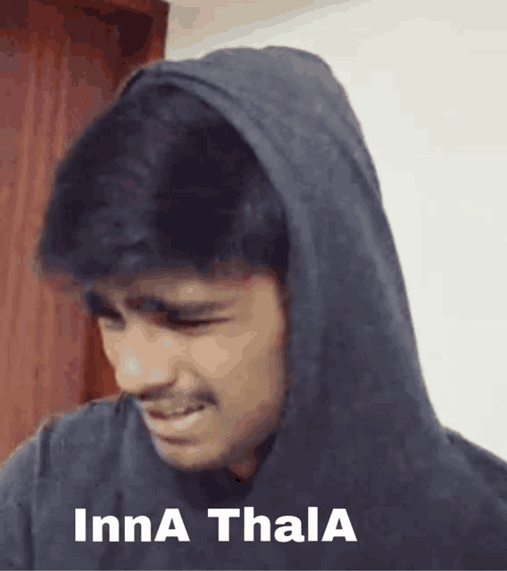 a man wearing a hooded sweatshirt with the words inna thala written on it