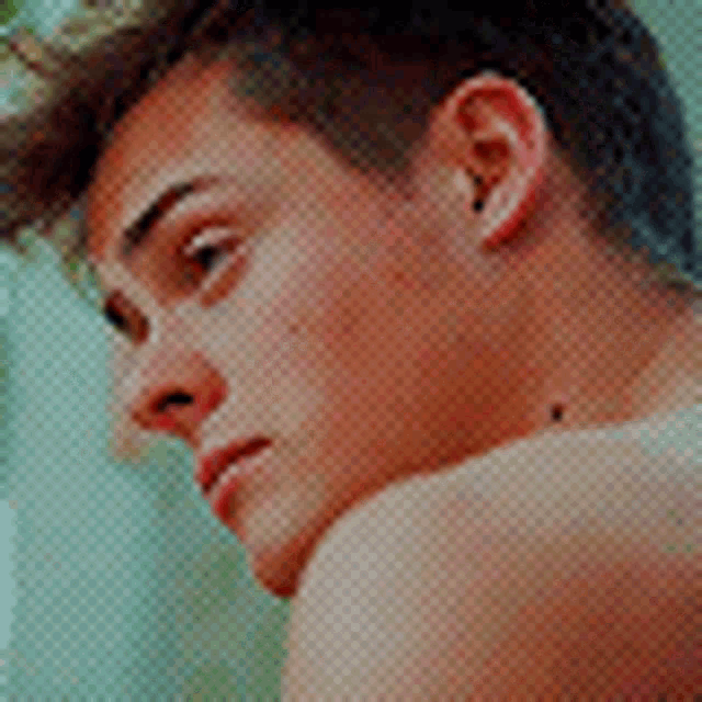 a close up of a young man 's face with a serious look on his face .