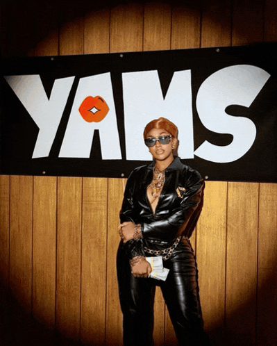 a woman stands in front of a yans sign