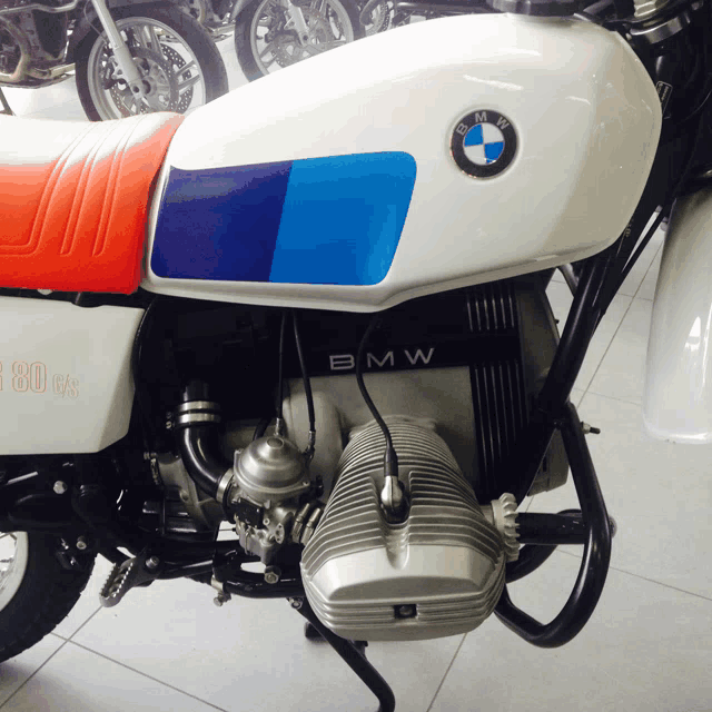 a white bmw motorcycle with blue and red stripes on the side