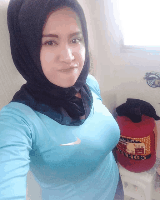 a woman wearing a hijab and a blue nike shirt