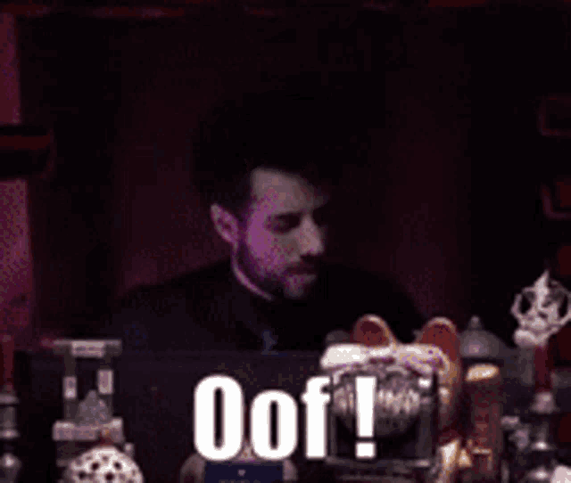 a man is sitting in front of a laptop with the words oof written on the screen