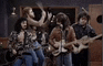 a group of people are playing guitars in a recording studio .