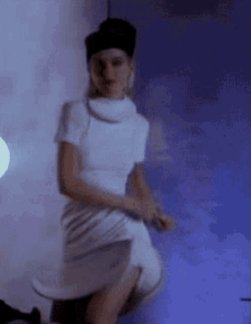 a woman in a white dress and hat is dancing