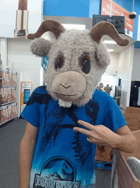 a person wearing a stuffed goat mask and a jurassic world shirt