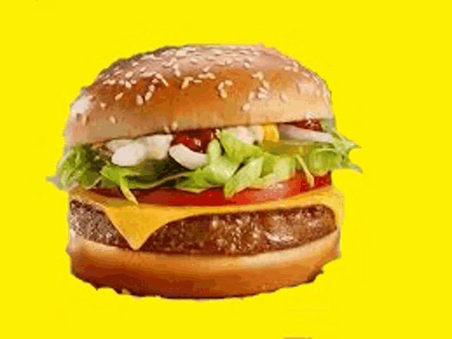 a hamburger with cheese , lettuce , tomatoes , onions , and sesame seeds on a yellow background .