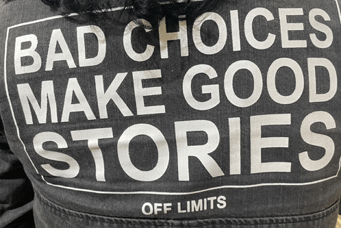 a person wearing a black jacket that says bad choices make good stories