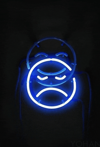 a neon sign with a sad face on it