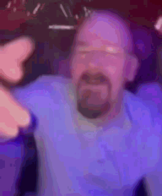 a blurry picture of a man with a beard and a blue shirt