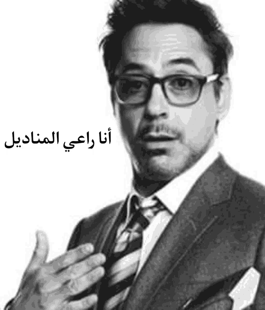 a black and white photo of a man in a suit and tie with arabic writing on it .