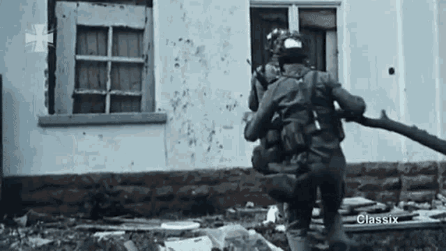 a group of soldiers are walking in front of a house .