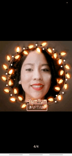 a woman 's face is surrounded by christmas lights and says yum yum captain .