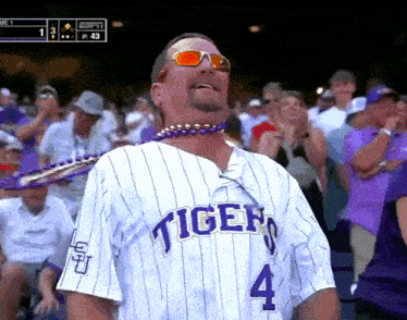 a man wearing a striped tigers jersey with the number 4 on it