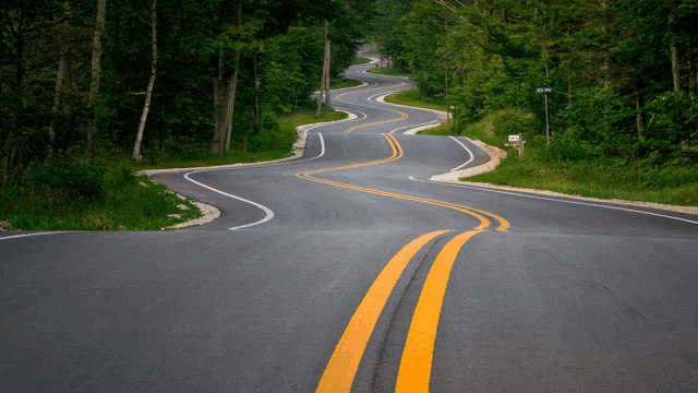 a winding road with a mailbox on the right