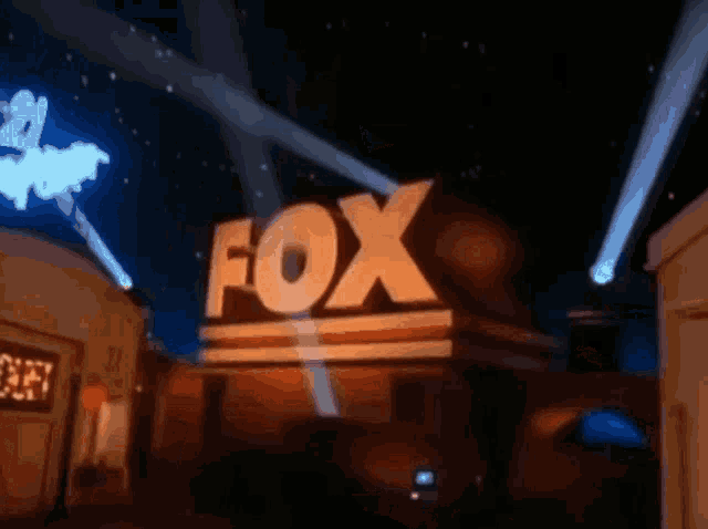 a fox logo is lit up in the night sky