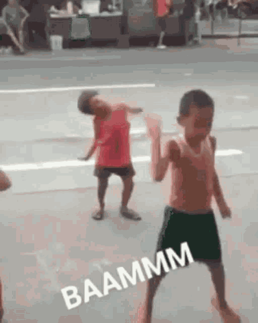 a couple of young boys are dancing on the side of a street .