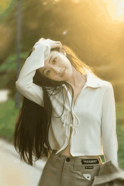 a woman wearing a white shirt that says " pleasant "