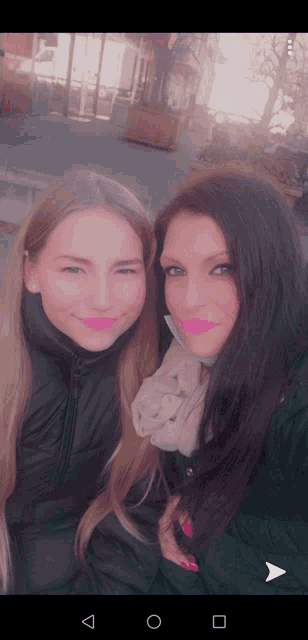 two women are posing for a picture and one has a pink lip