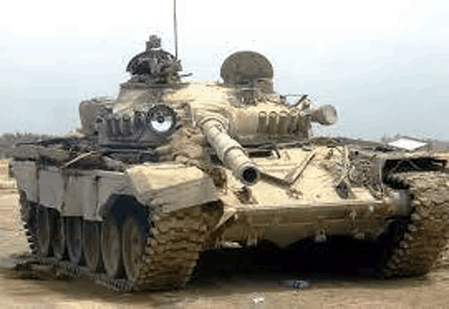 a large military tank is parked in the middle of a desert .