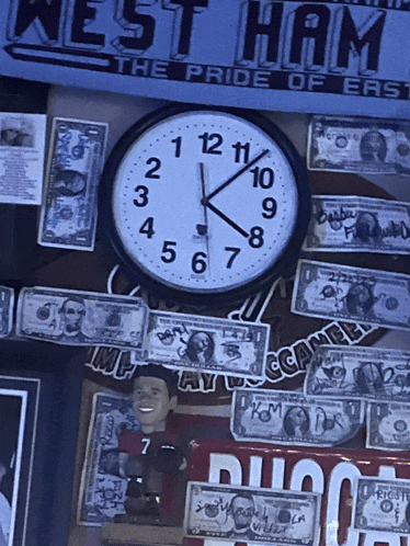 a clock is surrounded by money and a banner that says west ham the pride of east