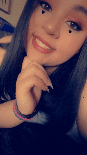 a girl with hearts on her face is smiling