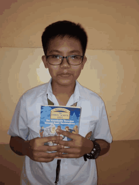 a boy in a white shirt holds a book titled the harley school kids